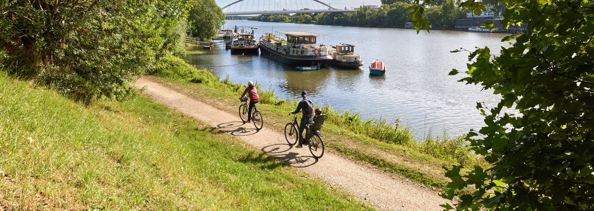 Famille faisant du vélo le long de la Maine, avec du beau temps © Alexandre Lamoureux