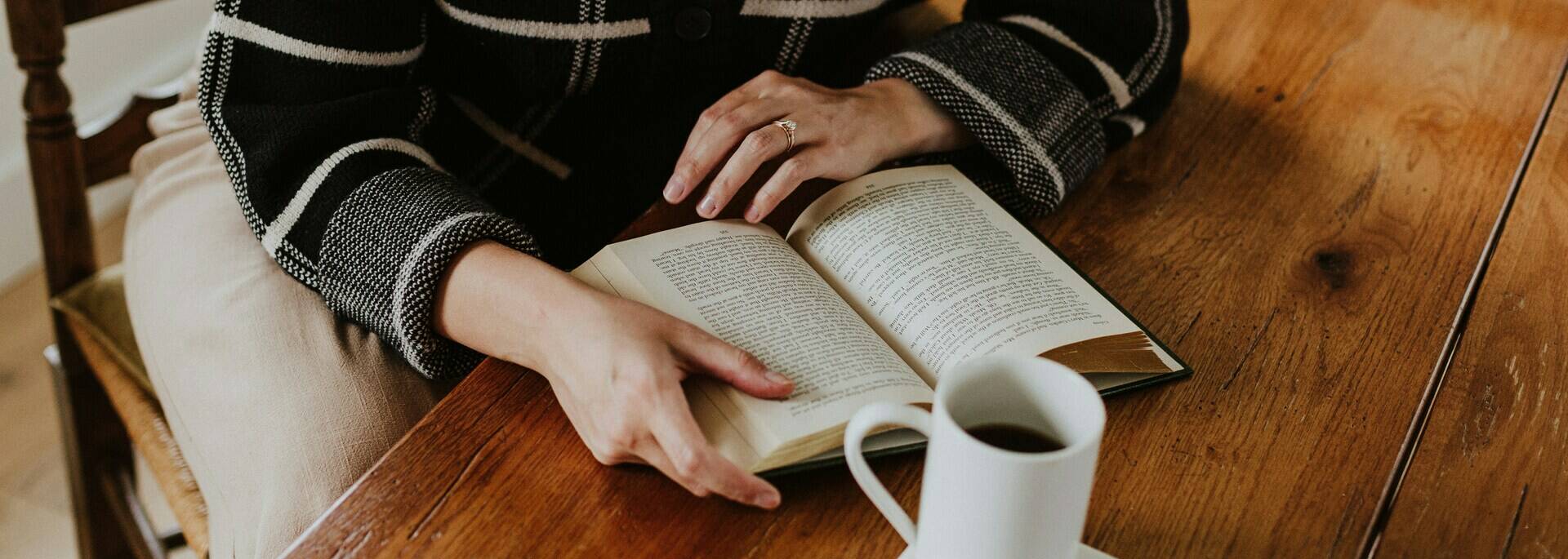 Femme qui lit un livre dans un café