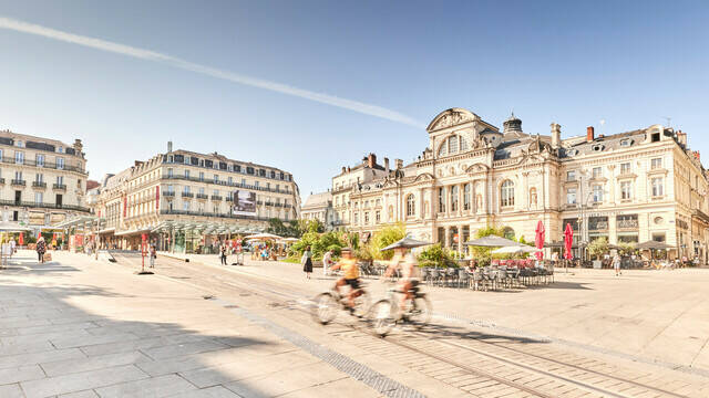 Deux cyclistes passant place du Ralliement devant le Grand Théâtre