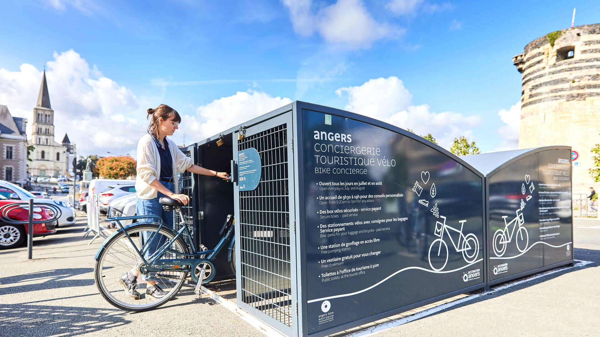 Jeune femme rangeant un vélo dans un box de la conciergerie vélo