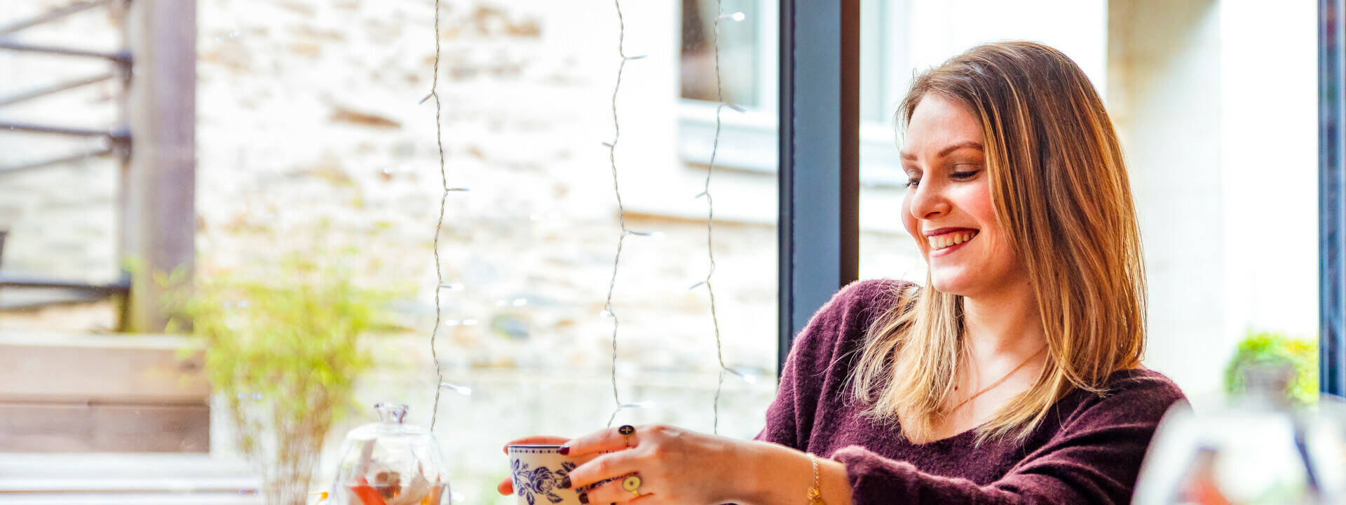 Jeune femme souriante assise à une table dans un salon de thé