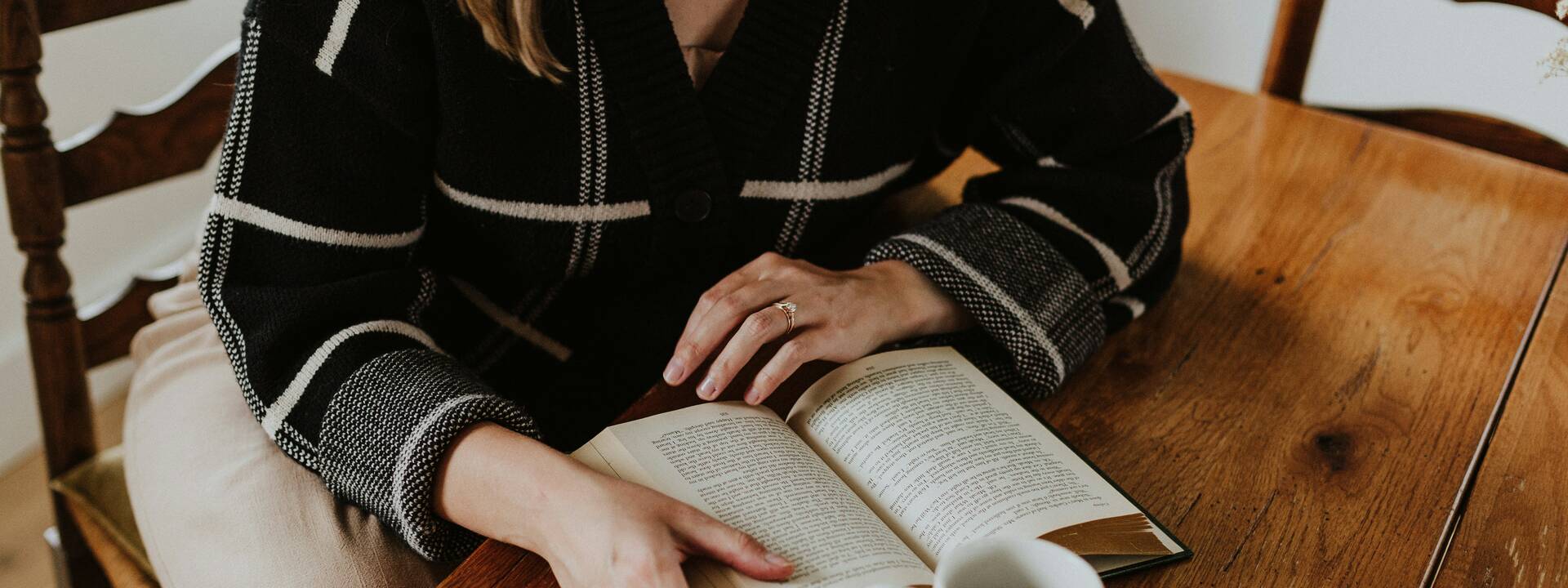 Femme qui lit un livre dans un café